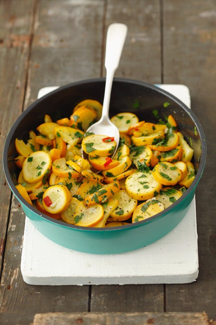 Fried yellow courgettes with garlic, chilli and parsley