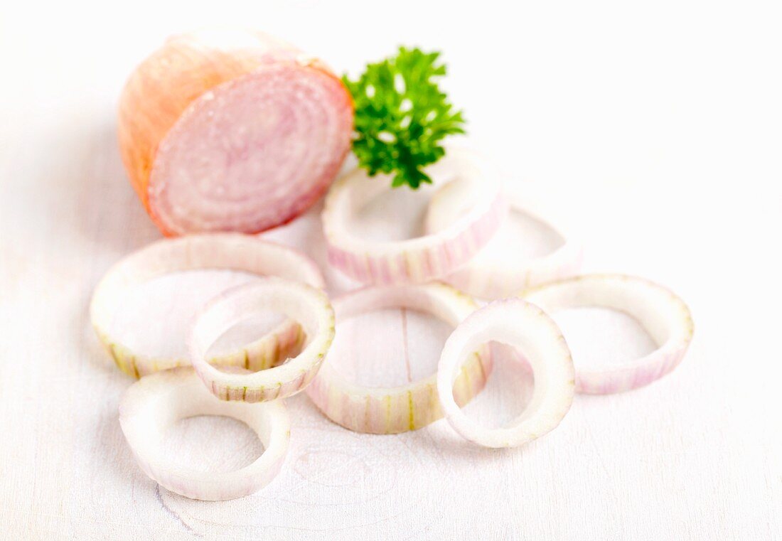 Shallots and shallot rings on a white surface