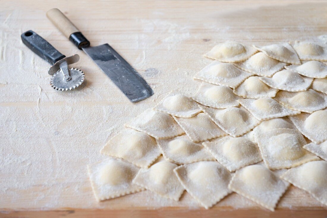 Frische, selbstgemachte Ravioli auf bemehlter Arbeitsplatte