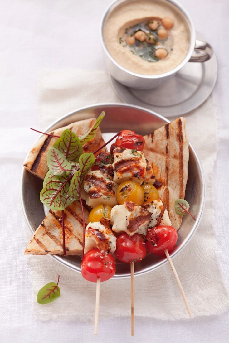Grilled haloumi and tomato kebabs with unleavened bread and hummus