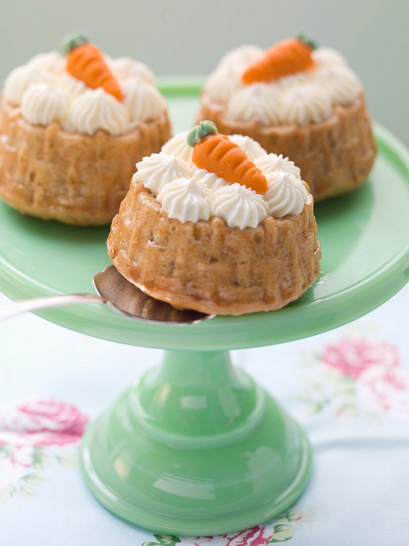 Mini carrot cakes topped with cream and marzipan carrots