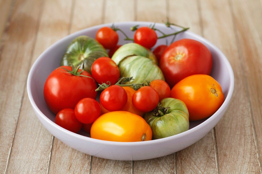 A bowl of red, green and yellow tomatoes