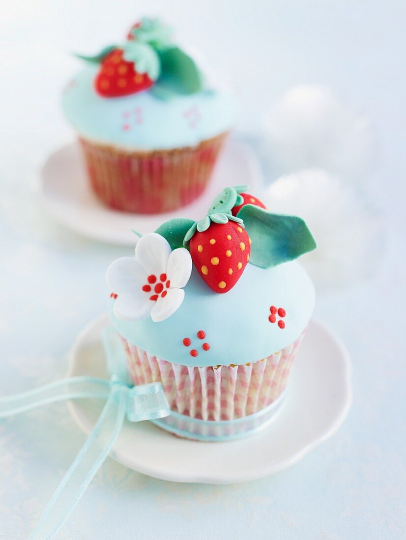 Cupcakes mit blauem Zuckerguss und Marzipandekoration