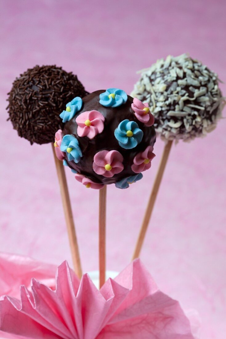 Schokoladen-Cake Pops mit Zuckerblüten und mit dunklen und hellen Schokostreuseln