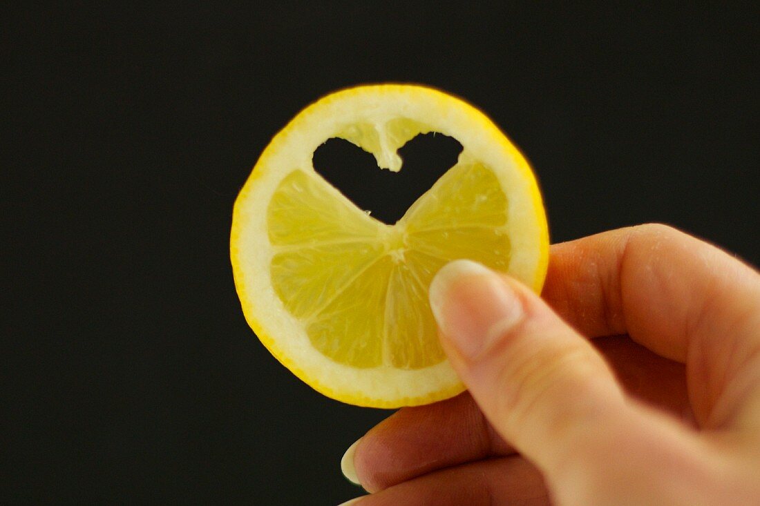 A slice of lemon with a heart-shaped piece cut out of it