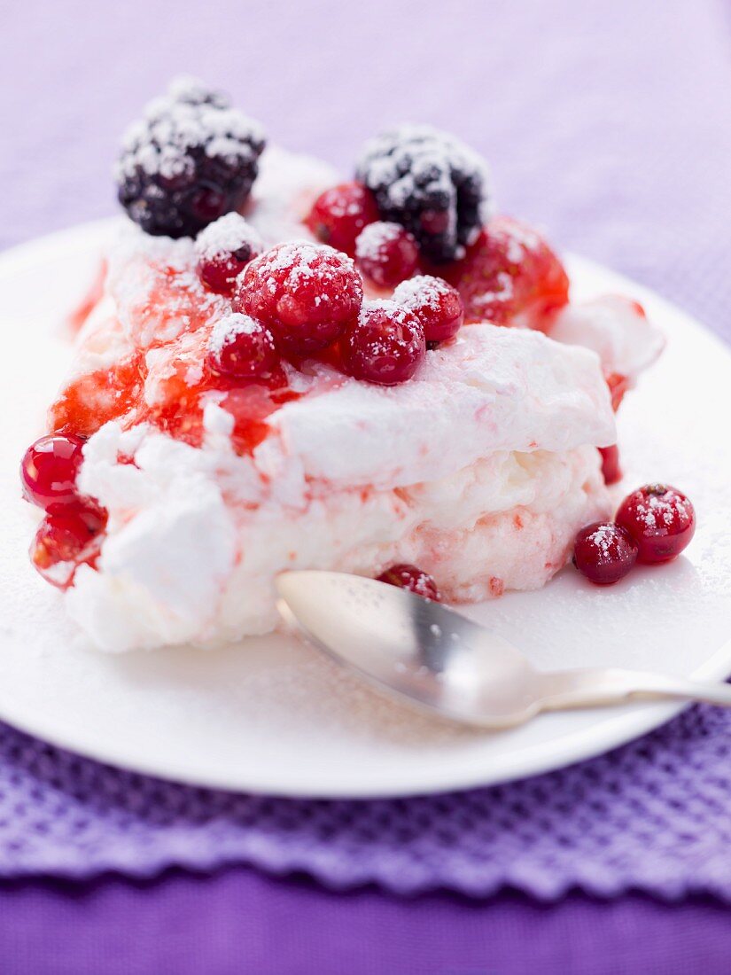 Ein Stück Pavlova-Torte mit Beeren auf Teller