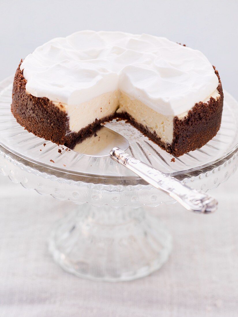 Chocolate cheesecake topped with cream, sliced