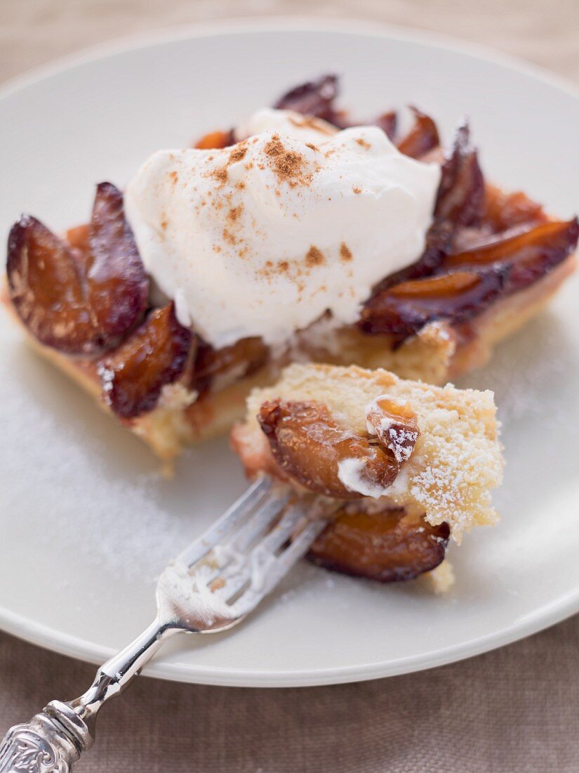 A slice of damson cake with cinnamon cream