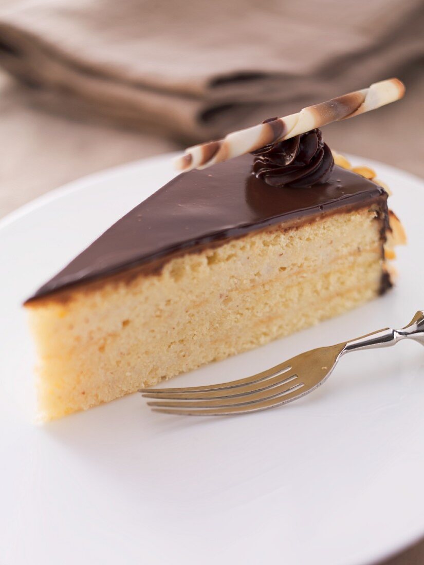A slice of Herrentorte (not too sweet layer cake topped with chocolate glaze) with a fork