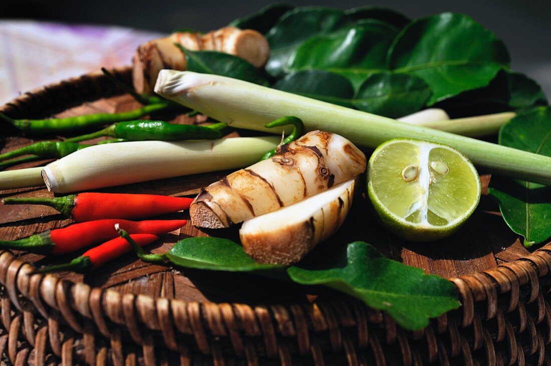 Soup ingredients from Thailand: chilli peppers, lemongrass, galangal, lemon leaves and limes