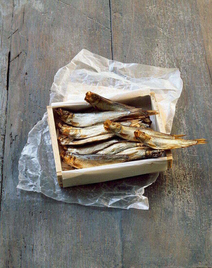 Smoked sardines in a wooden crate