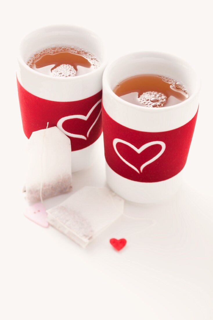 Teabags and two tea cups decorated with hearts