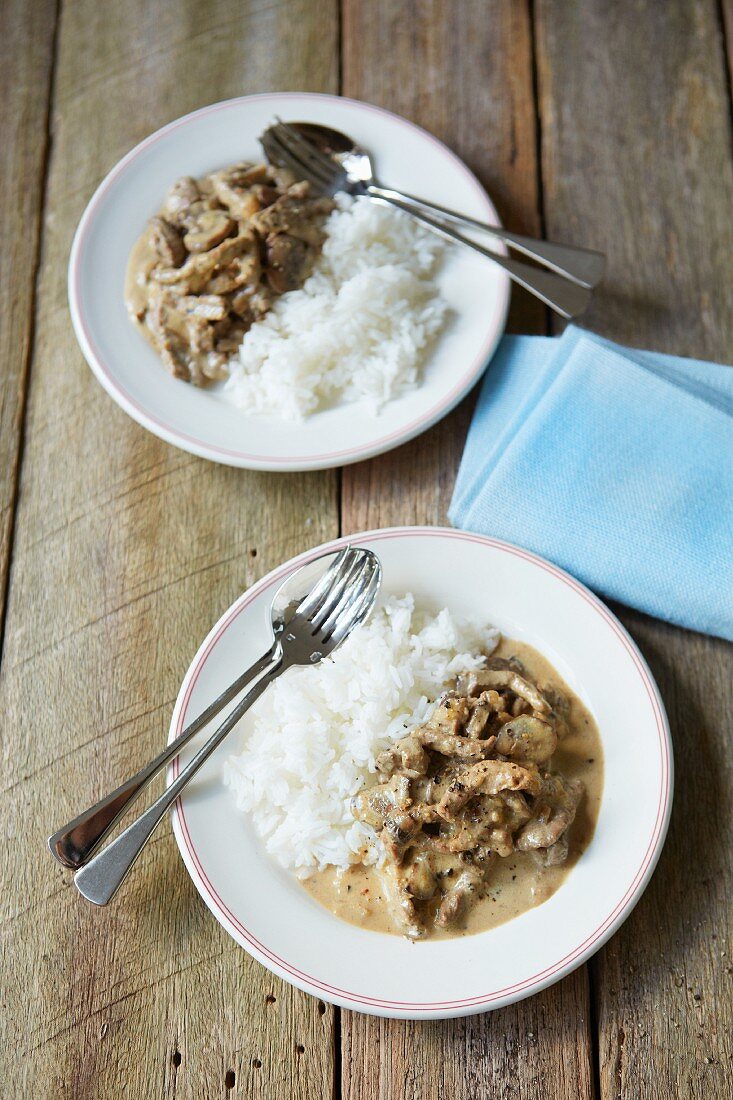 Two portions of beef stroganoff with rice