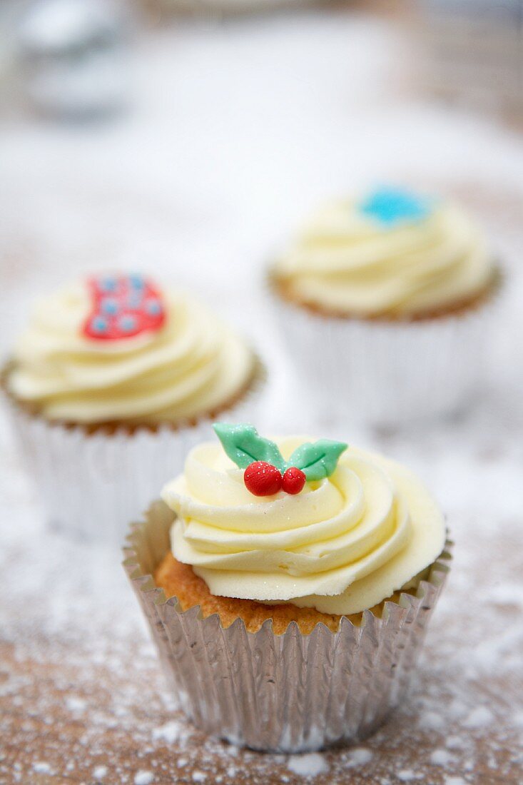 Cupcakes decorated with light frosting and marzipan decorations