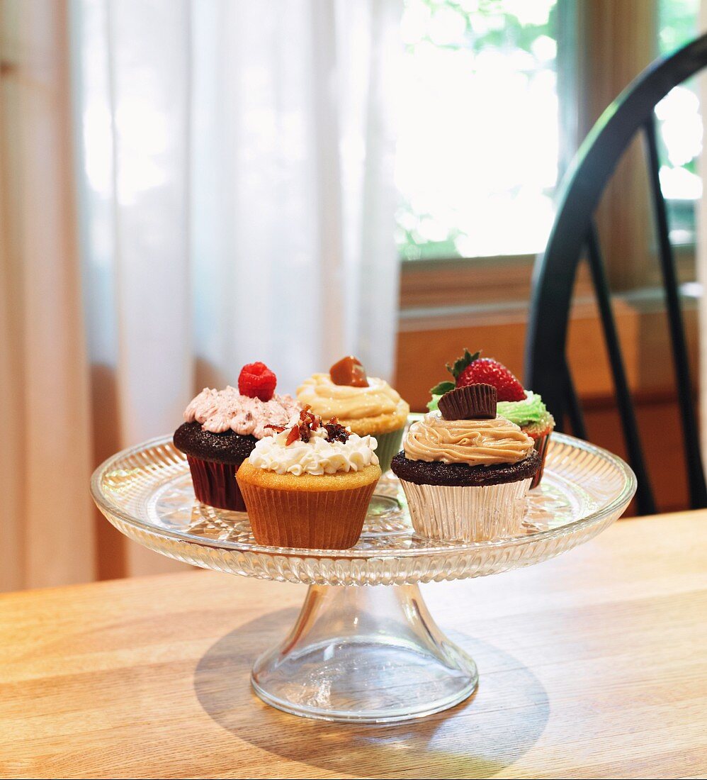 Assorted Homemade Cupcakes on a Pedestal Dish; On a Table