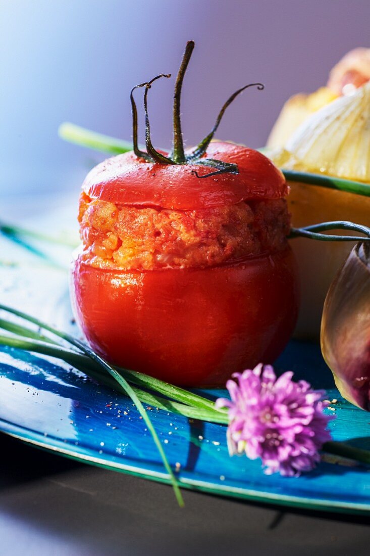 A stuffed tomato filled with toast, onion, raw ham and basil