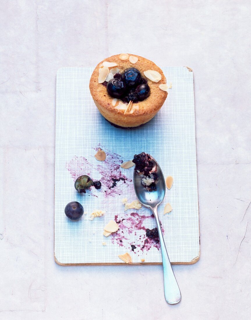 A blueberry muffin with slivered almonds