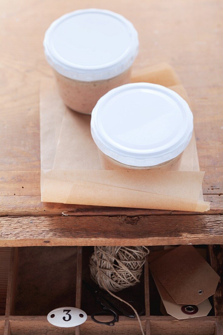 Two jars of homemade pate on a wooden table