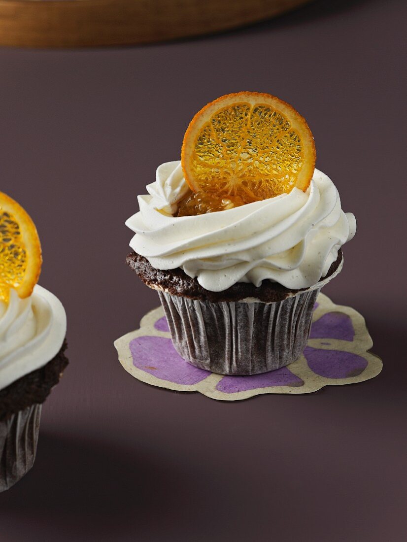 A cupcake decorated with cream and oranges
