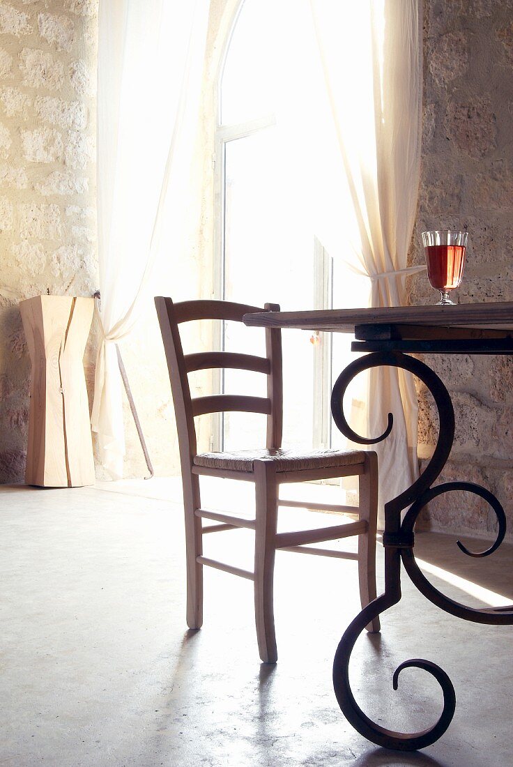 Dining table with wrought iron frame in interior of Chateau Maignaut (Pyrenees, France)