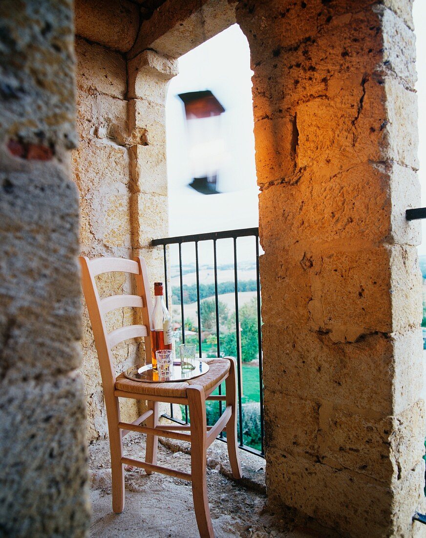 Tray on chair in unglazed tower window of Château Maignaut (Pyrenees, France)