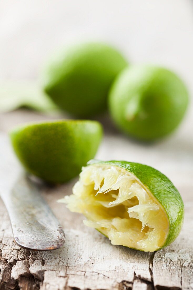 A half juiced lime with whole limes in the background