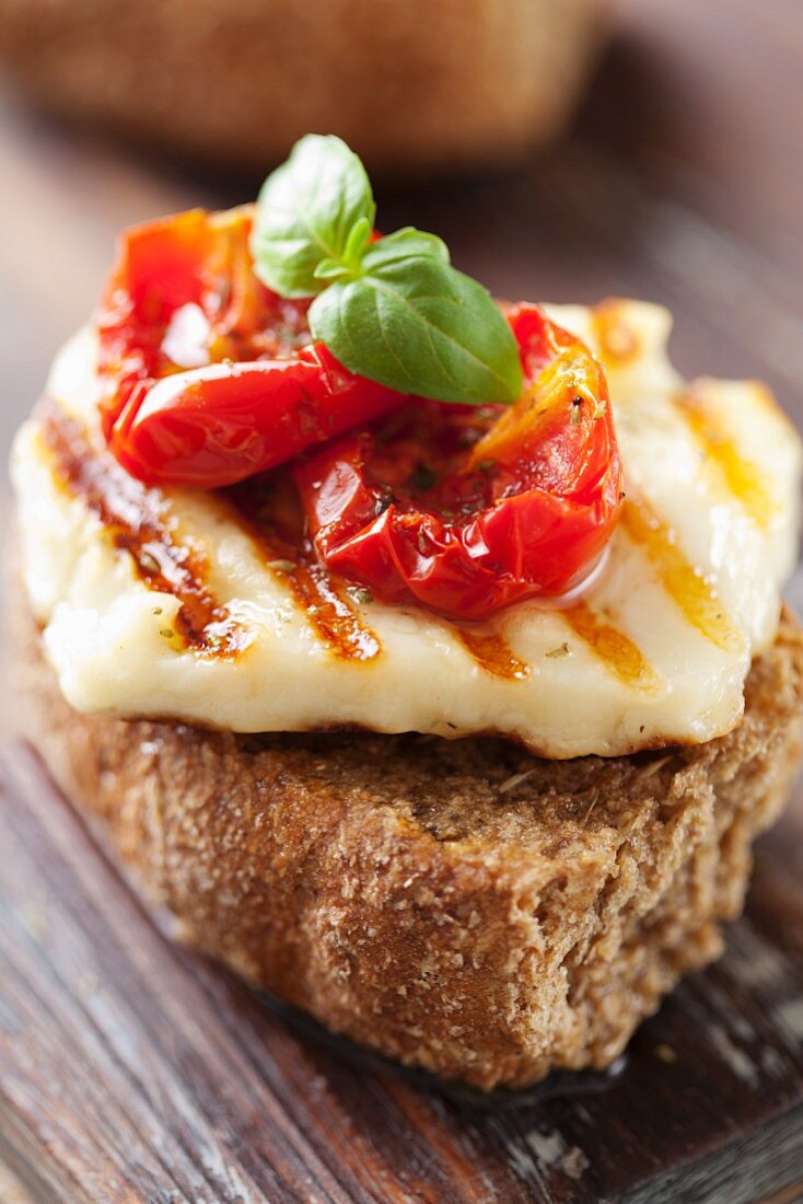 A wholemeal roll topped with grilled halloumi and sun-dried tomatoes