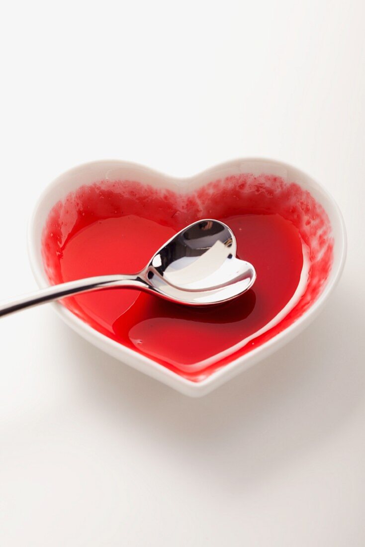An empty heart-shaped bowl with a heart-shaped spoon