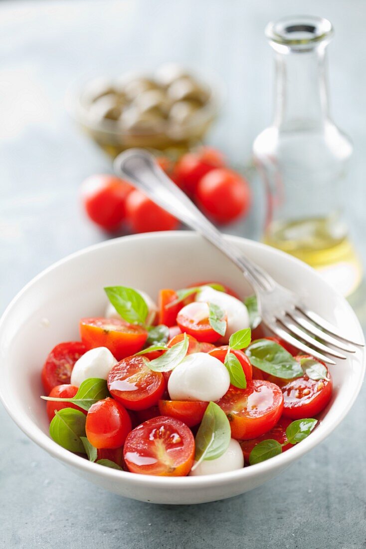 Tomatensalat mit kleinen Mozzarellakugeln und Basilikum
