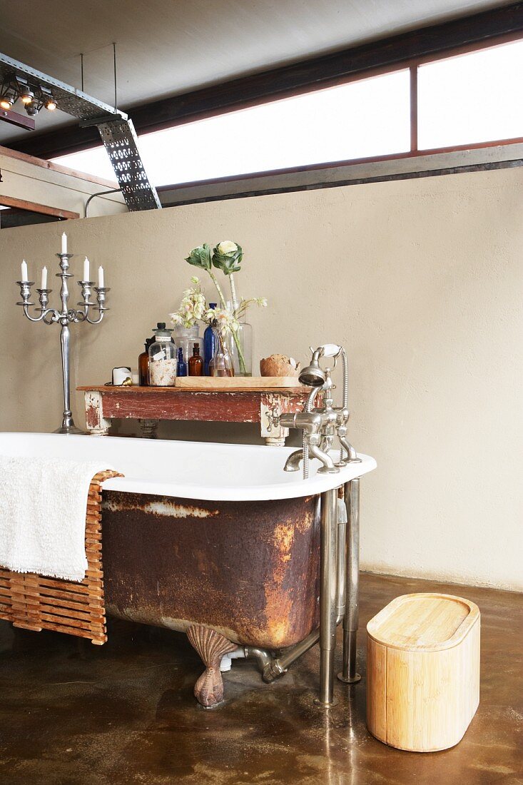 Free-standing bathtub, re-enamelled inside and rusty outside, with standpipe tap fittings in purist, vintage bathroom