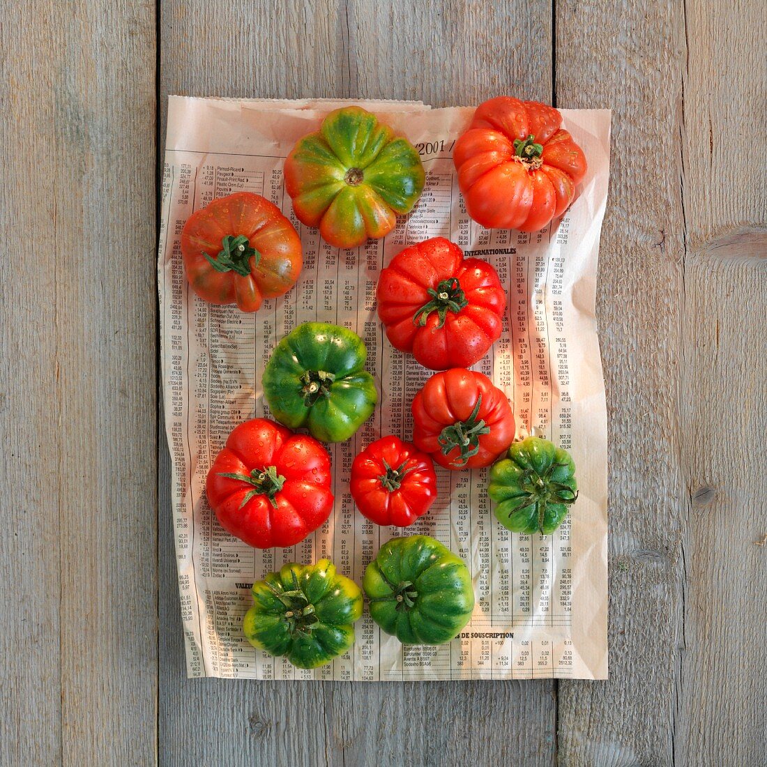 Green and red tomatoes on newspaper