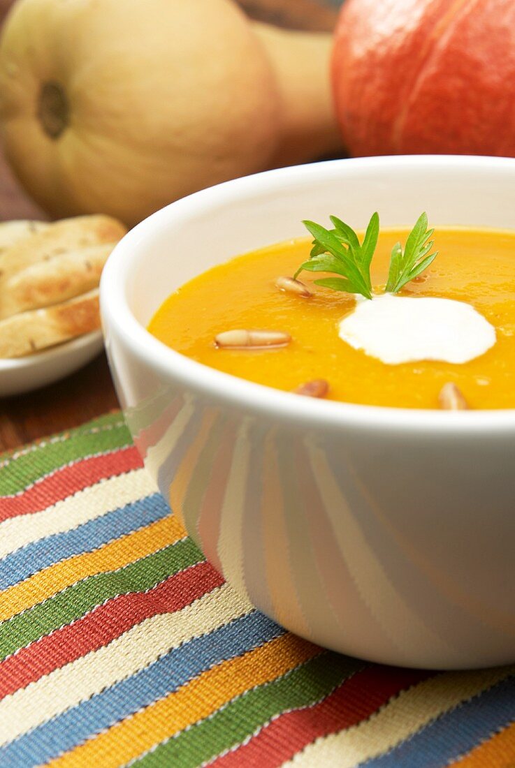 Kürbissuppe mit Sahneklecks und gerösteten Pinienkernen