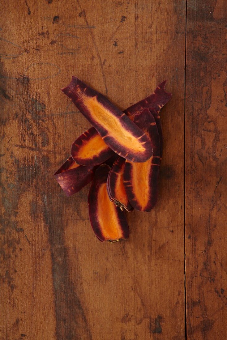 Several carrot strips on a wooden surface