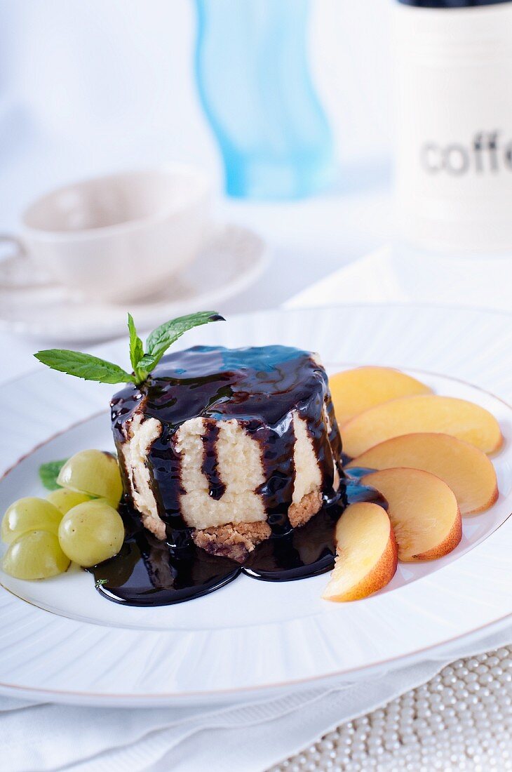 Kleiner Käsekuchen mit Schokoladensauce, Trauben und Nektarinen