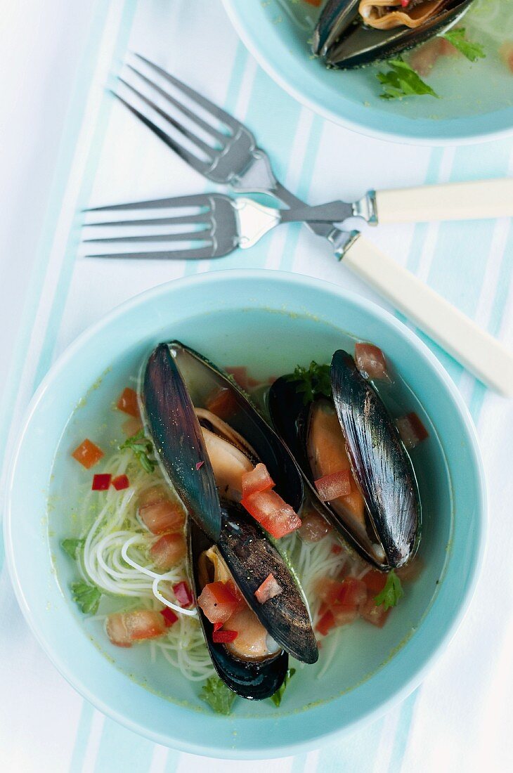 Mussel soup with rice noodles and tomatoes