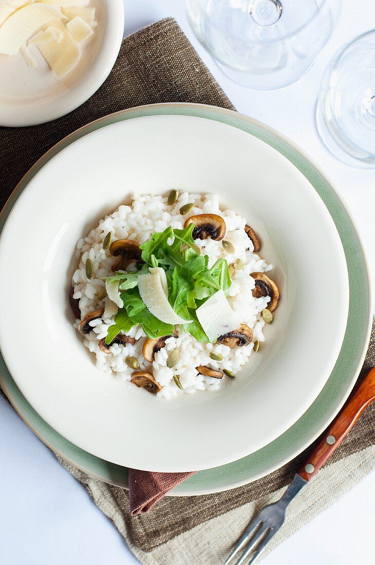 Risotto with mushrooms, pumpkin seeds, rocket and Parmesan