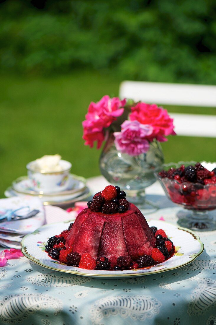 Summer pudding with blackberries on a table in the garden