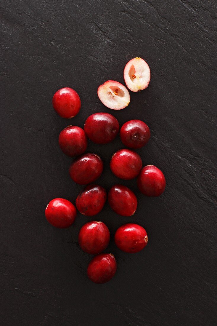 Cranberries, whole and halved, on a slate platter