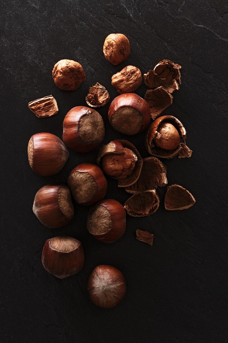 Hazelnuts, whole and cracked, on a slate platter