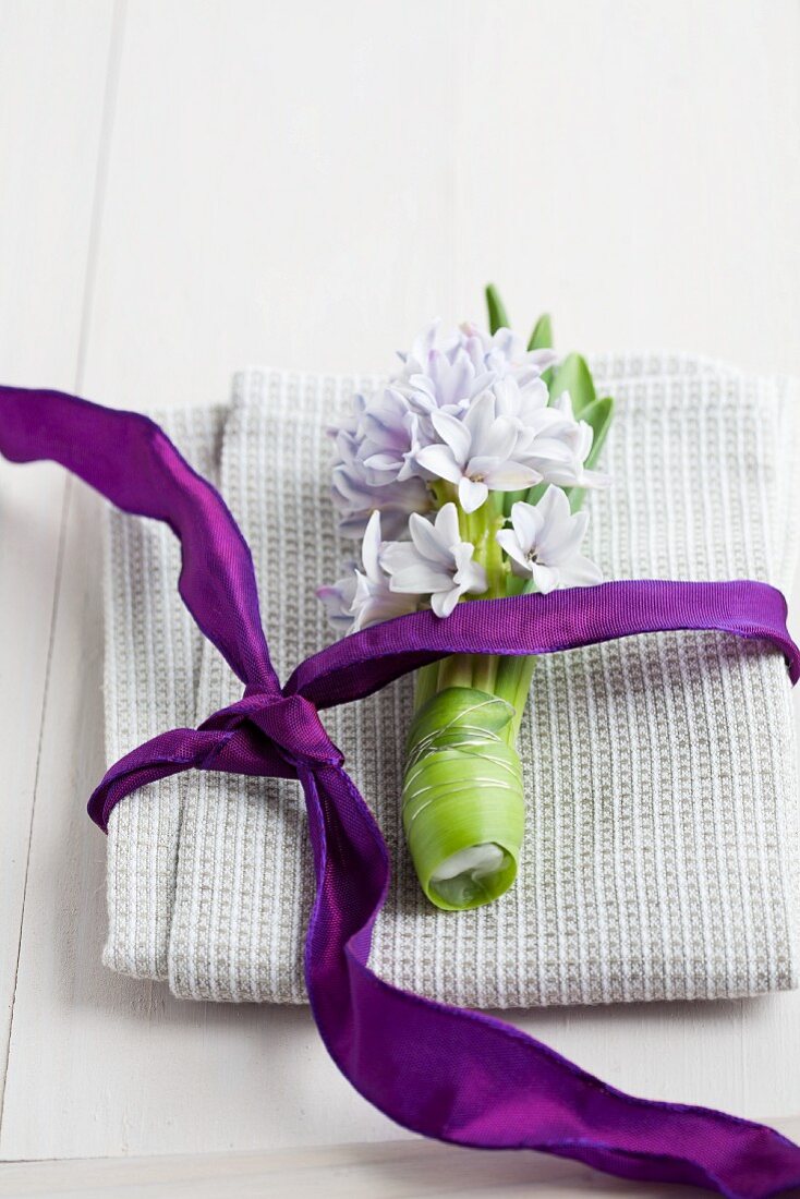 Hyacinth and purple ribbon on linen napkin