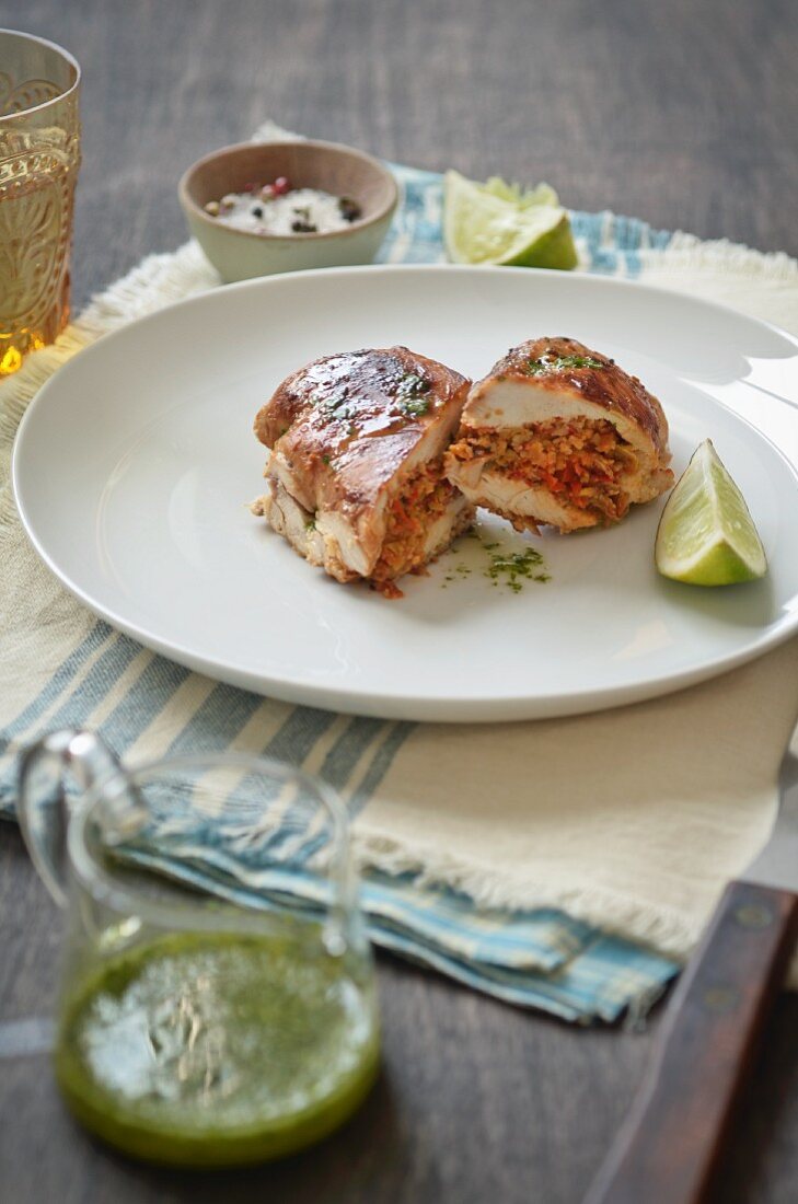 Stuffed chicken breast with a herb sauce and limes
