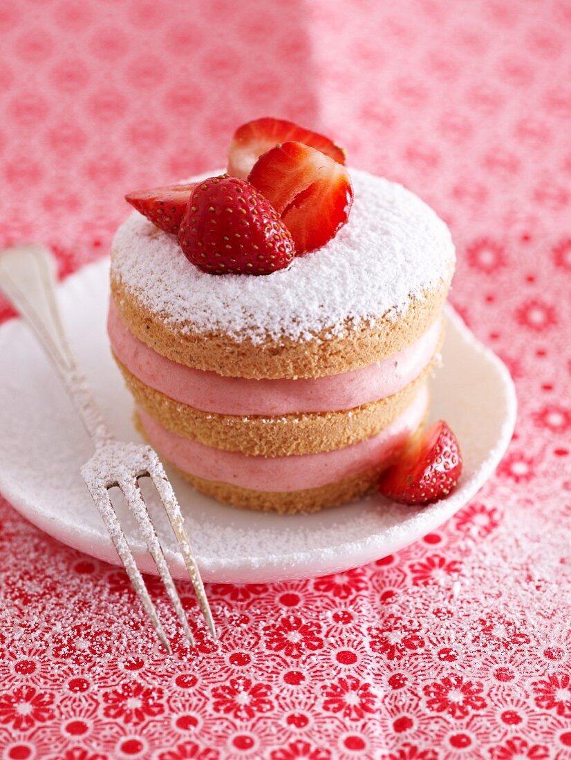 A strawberry tartlet with icing sugar