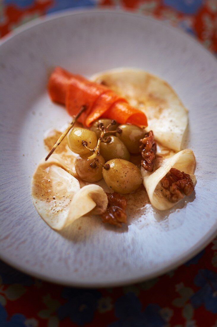 Celery carpaccio with pumpkin, nuts and grapes