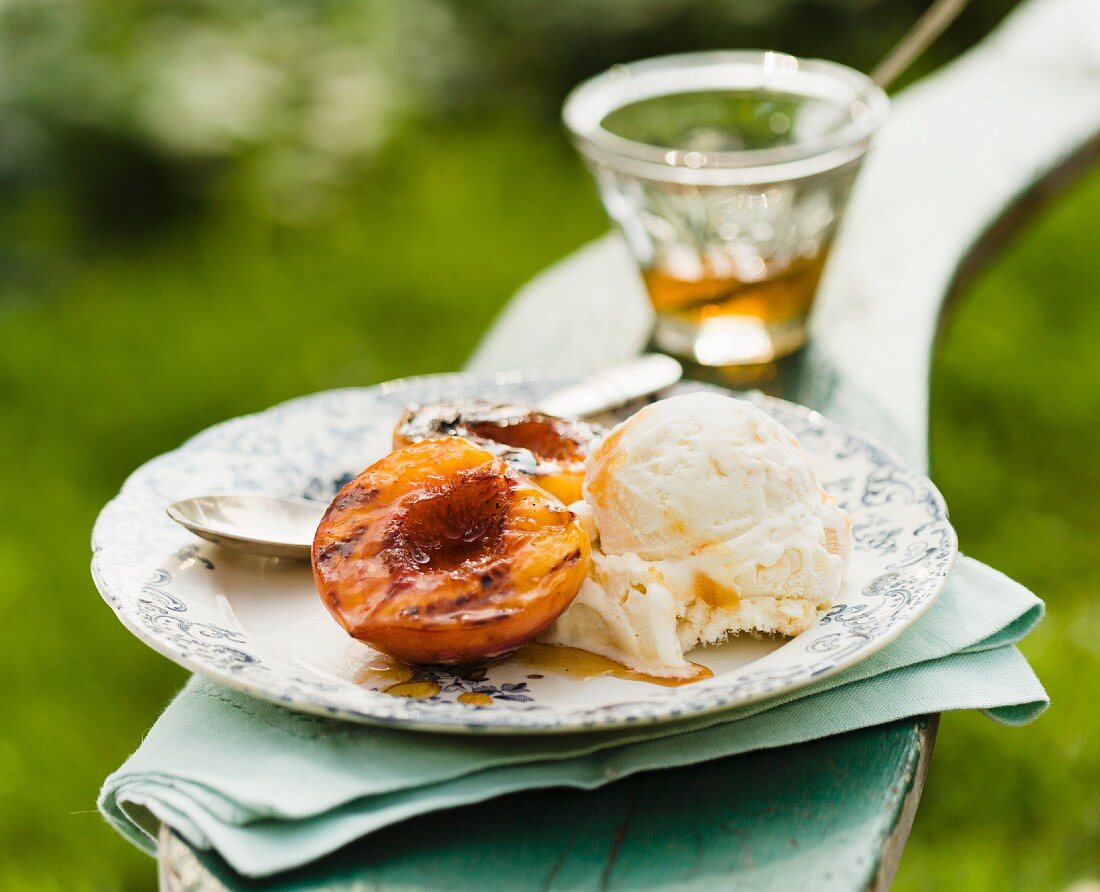 Gegrillter Pfirsich mit Honig und einer Kugel Vanilleeis