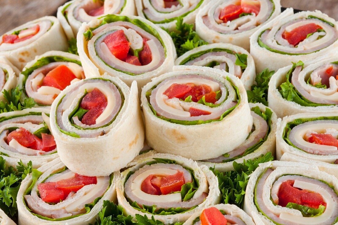 Ham, Cheese, Lettuce and Tomato Wraps; Sliced on a Platter