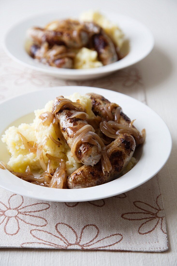 Two Bowls of Bangers and Mash with Onions