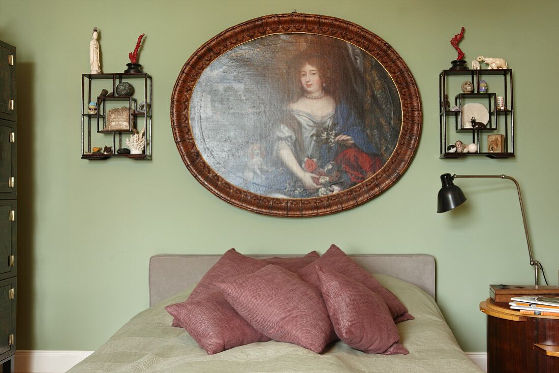 Traditional portrait of woman and wall racks of memorabilia above French bed