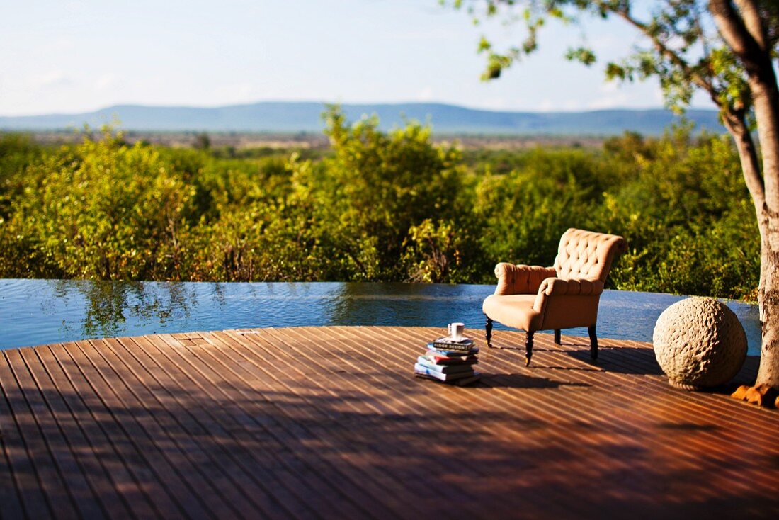 Infinitypool mit weitem Holzdeck vor weiter Landschaft