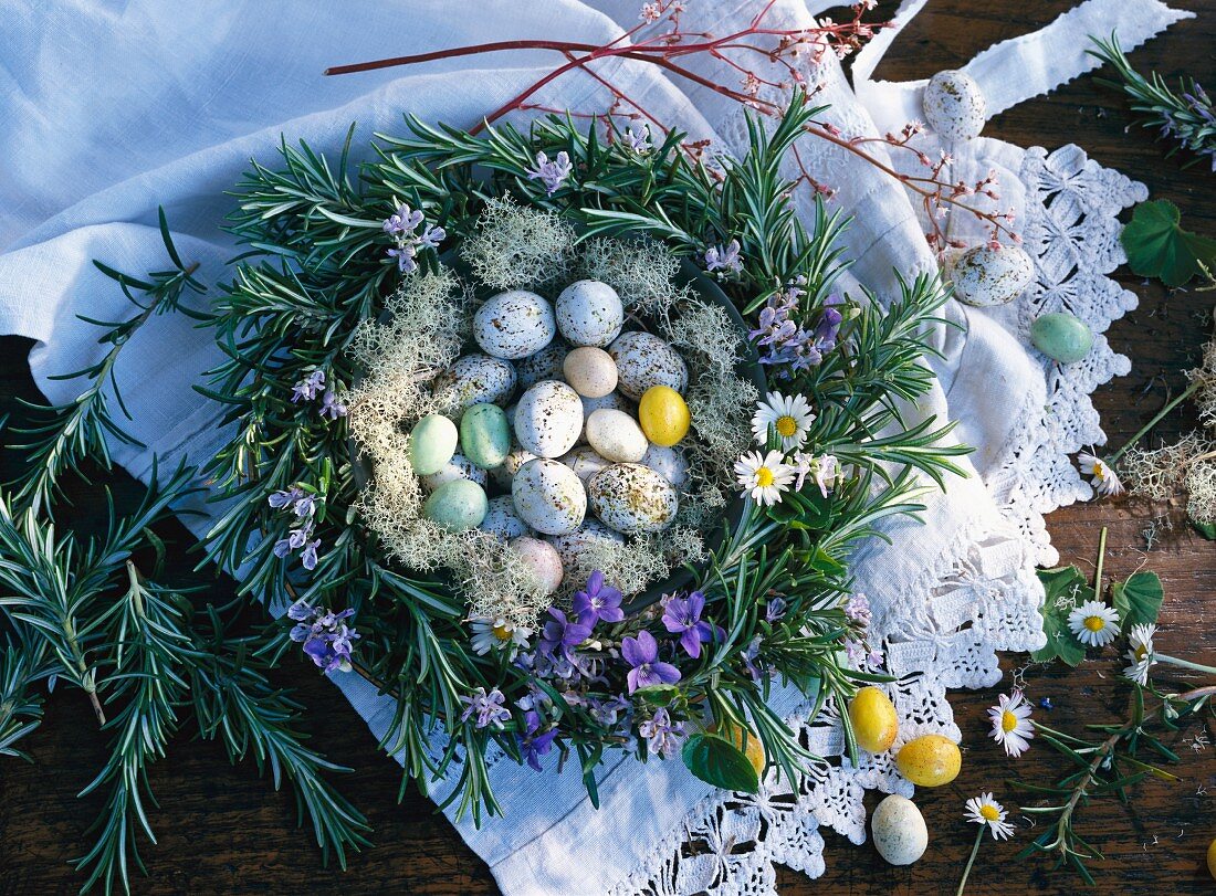 Ostereier im Rosmarinkranz mit Veilchen und Gänseblümchen