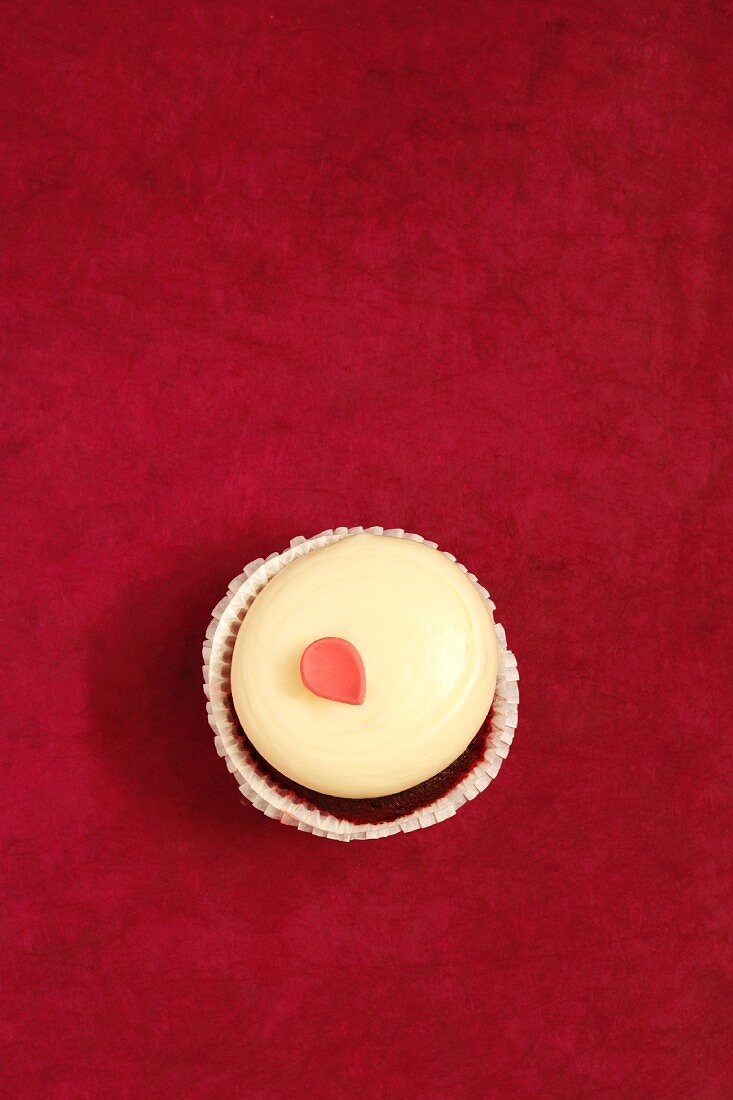 A Red Velvet Cupcake with One Pink Frosting Petal; From Above